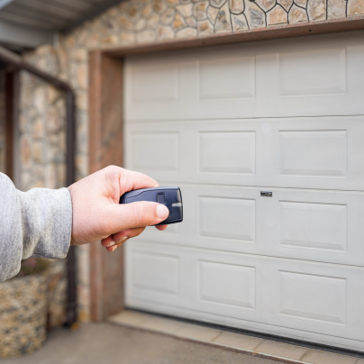 Mobile security key fob pointing to a garage door